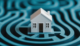 Maison blanche au centre d'un labyrinthe bleu, symbole des diagnostics immobiliers avant vente