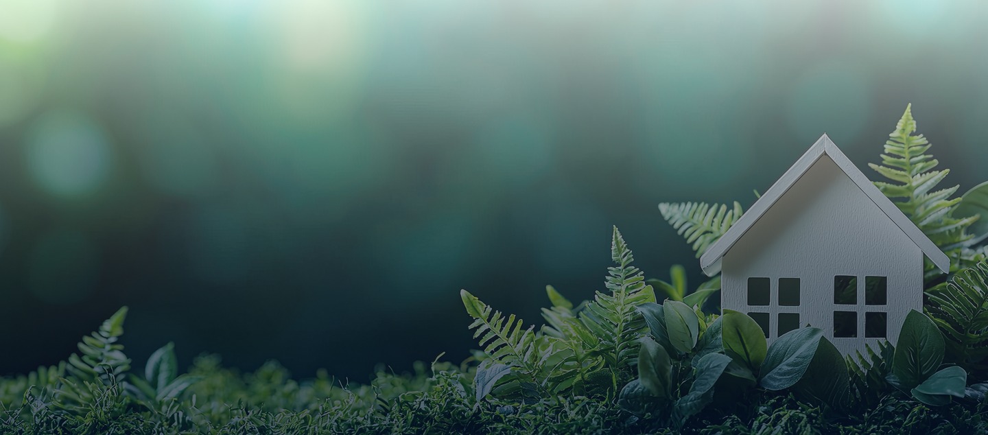Maison miniature blanche entourée d’une végétation luxuriante, symbole d’un habitat durable et respectueux de l’environnement